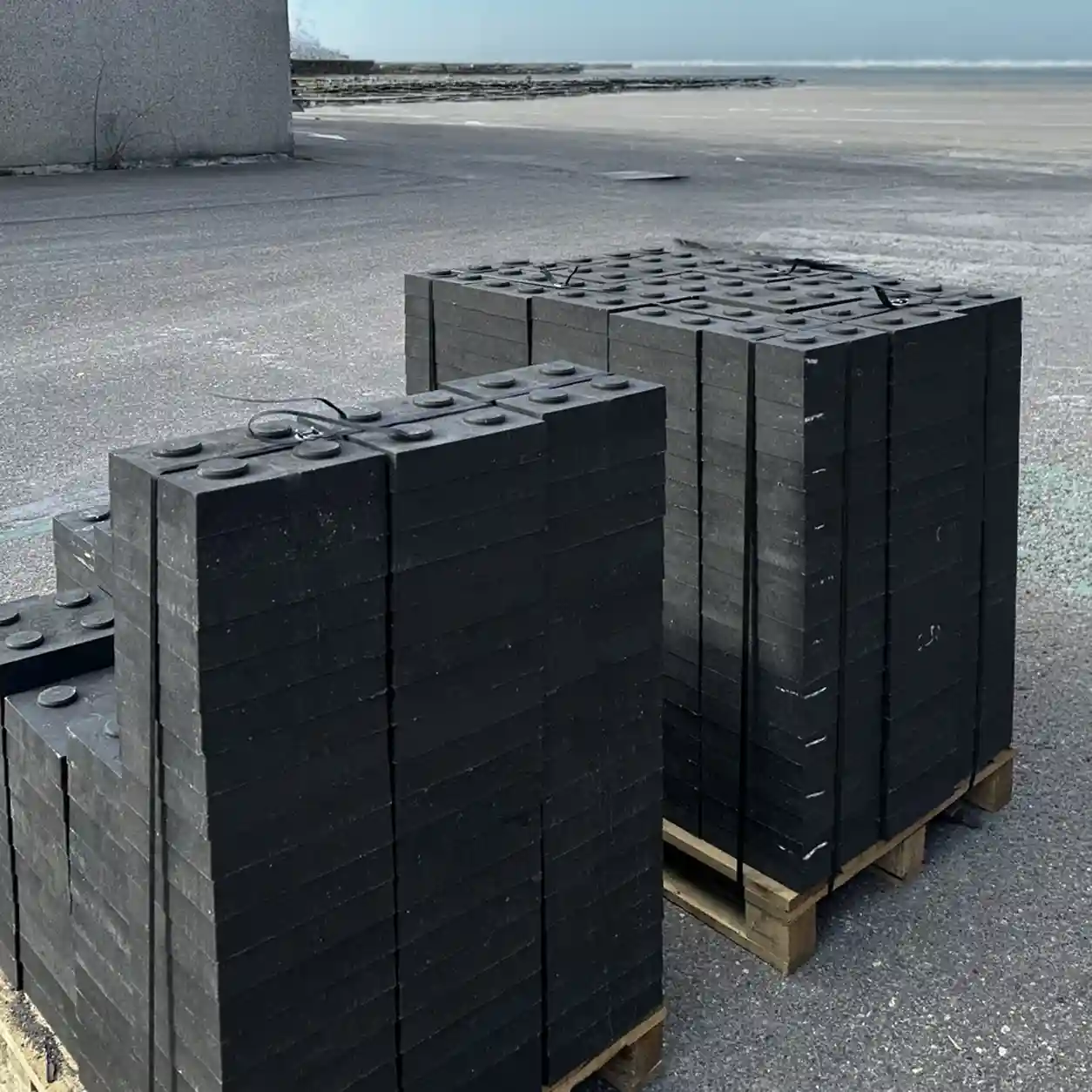 Grote serie zwarte kunststof ophoogblokken gestapeld op pallets