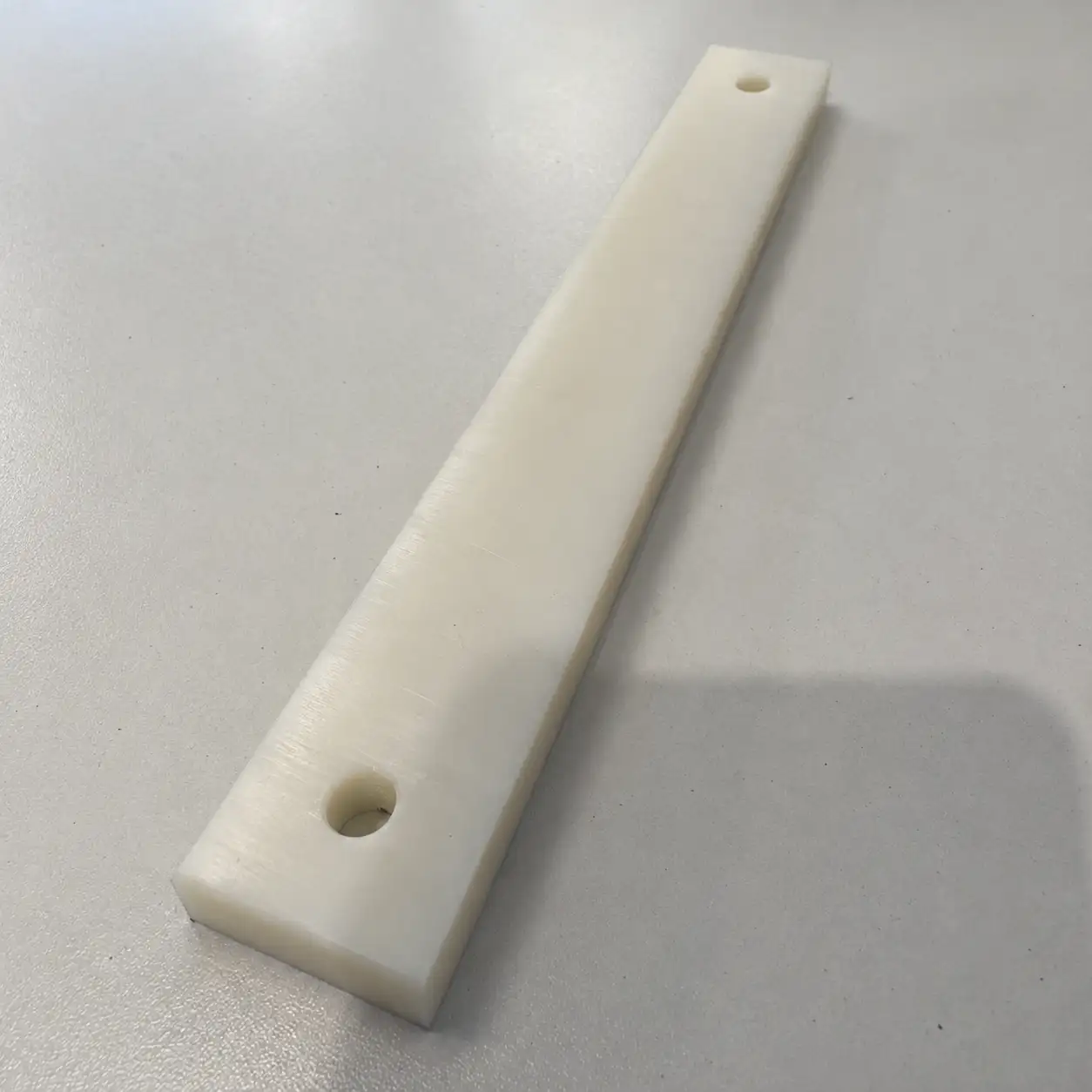 Naturelkleurige POM strip met twee montagegaten