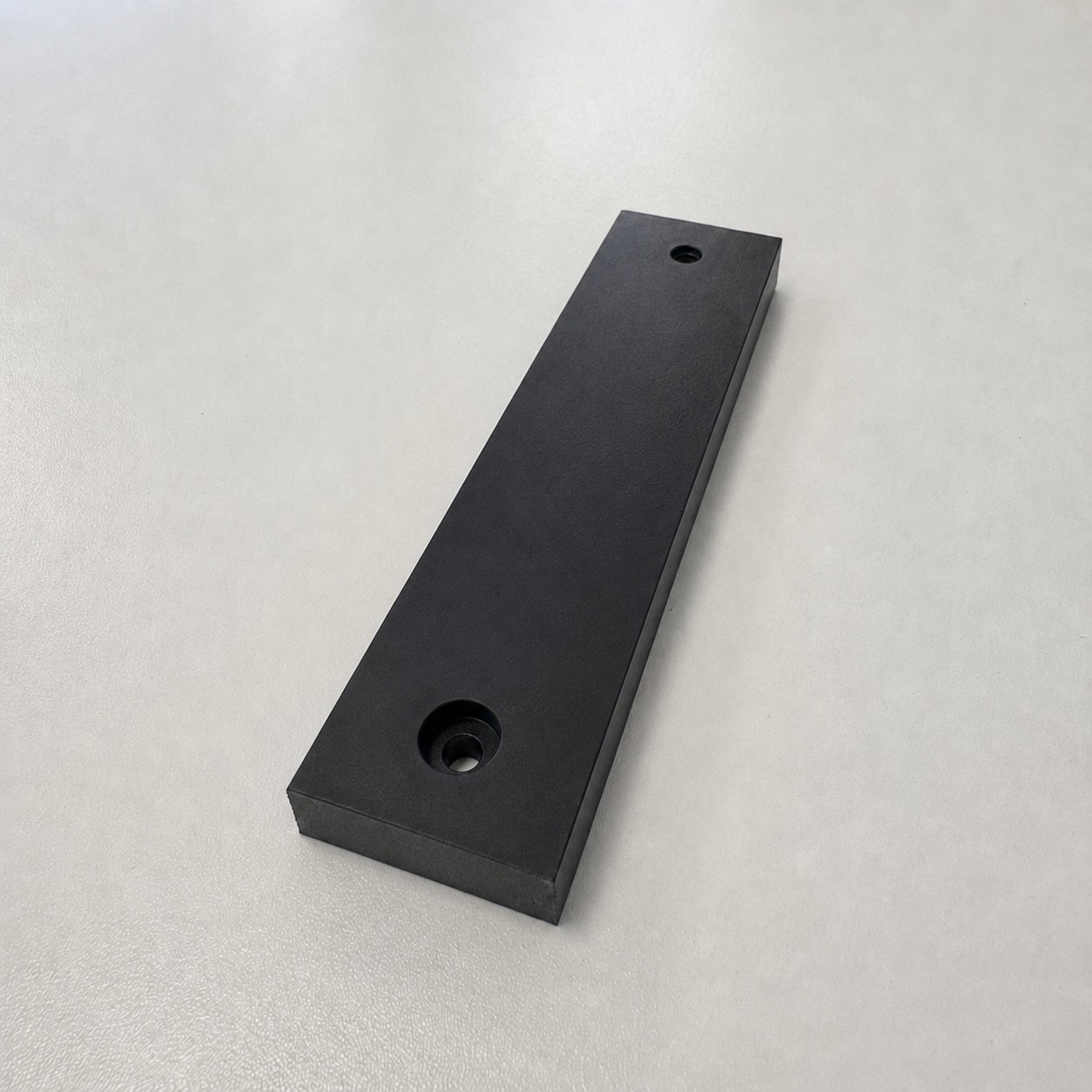 Zwart PVC blok op maat met geboorde en verzonken gaten