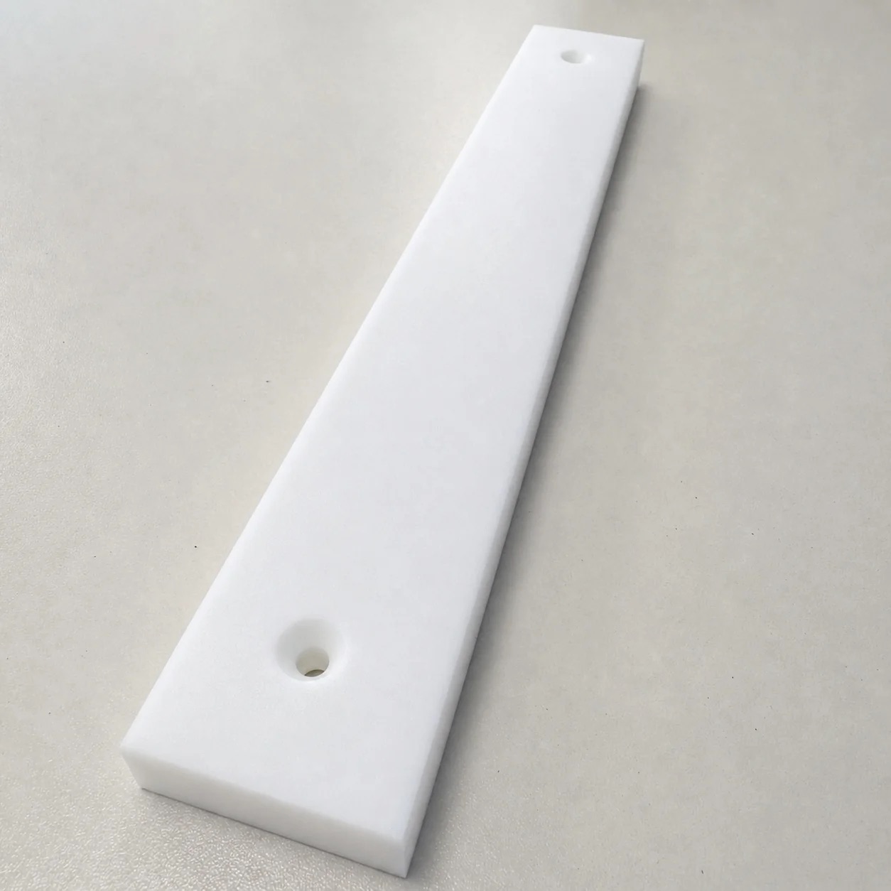 Witte Teflon strip met twee verzonken montagegaten